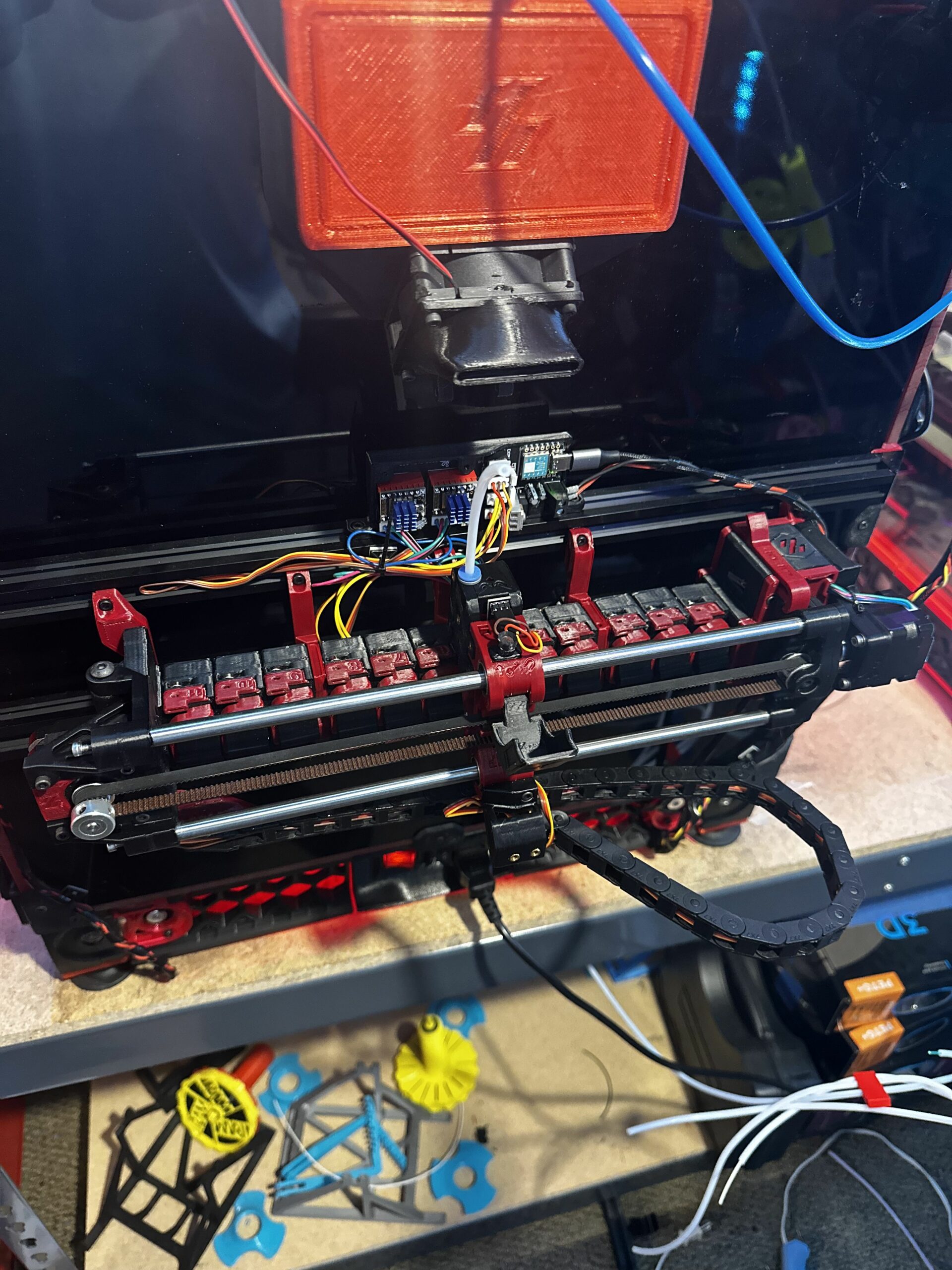 Exposed wiring, control electronics, belts, and toolhead on a custom 3D printer