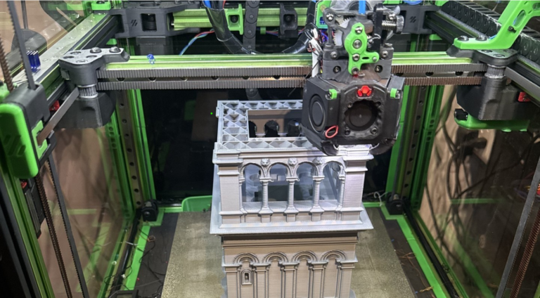 A 3D printer producing a detailed architectural building model.