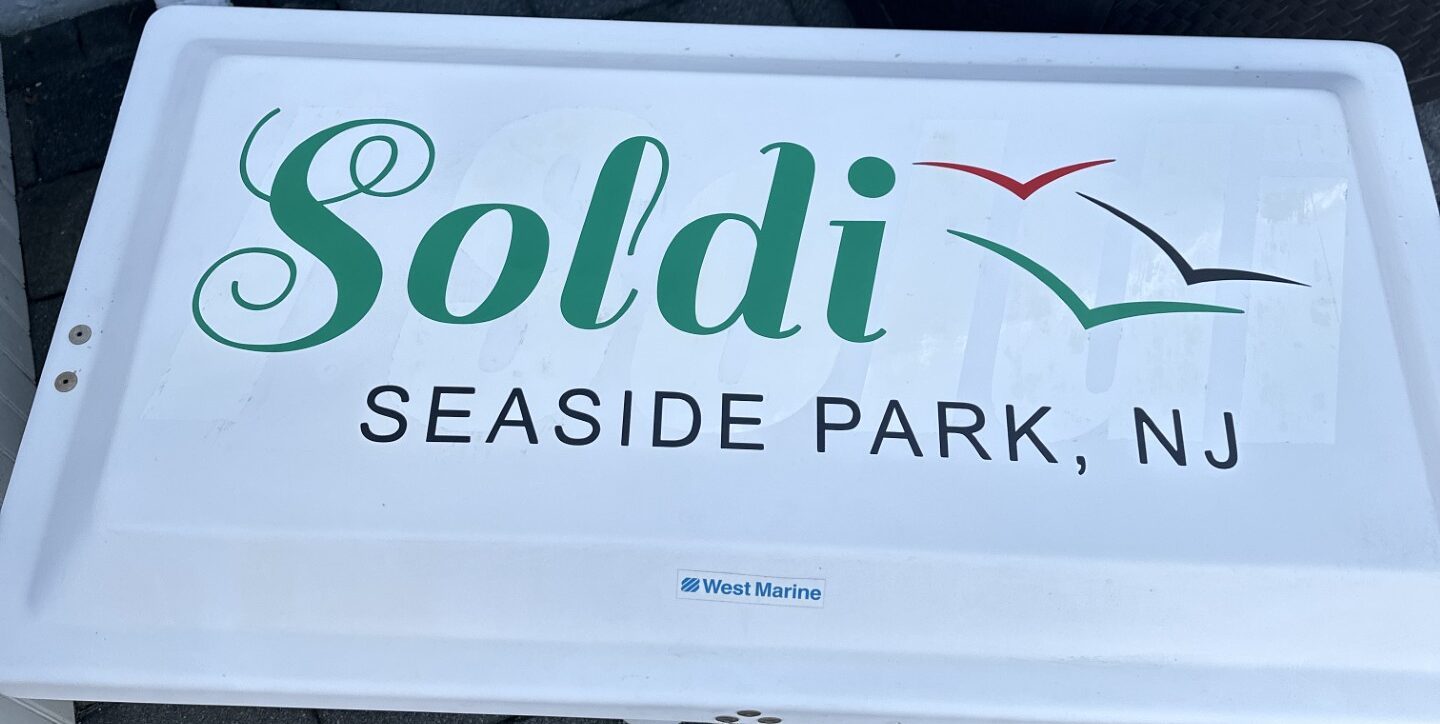 Multi-color cut-vinyl lettering and bird graphic on a white marine panel