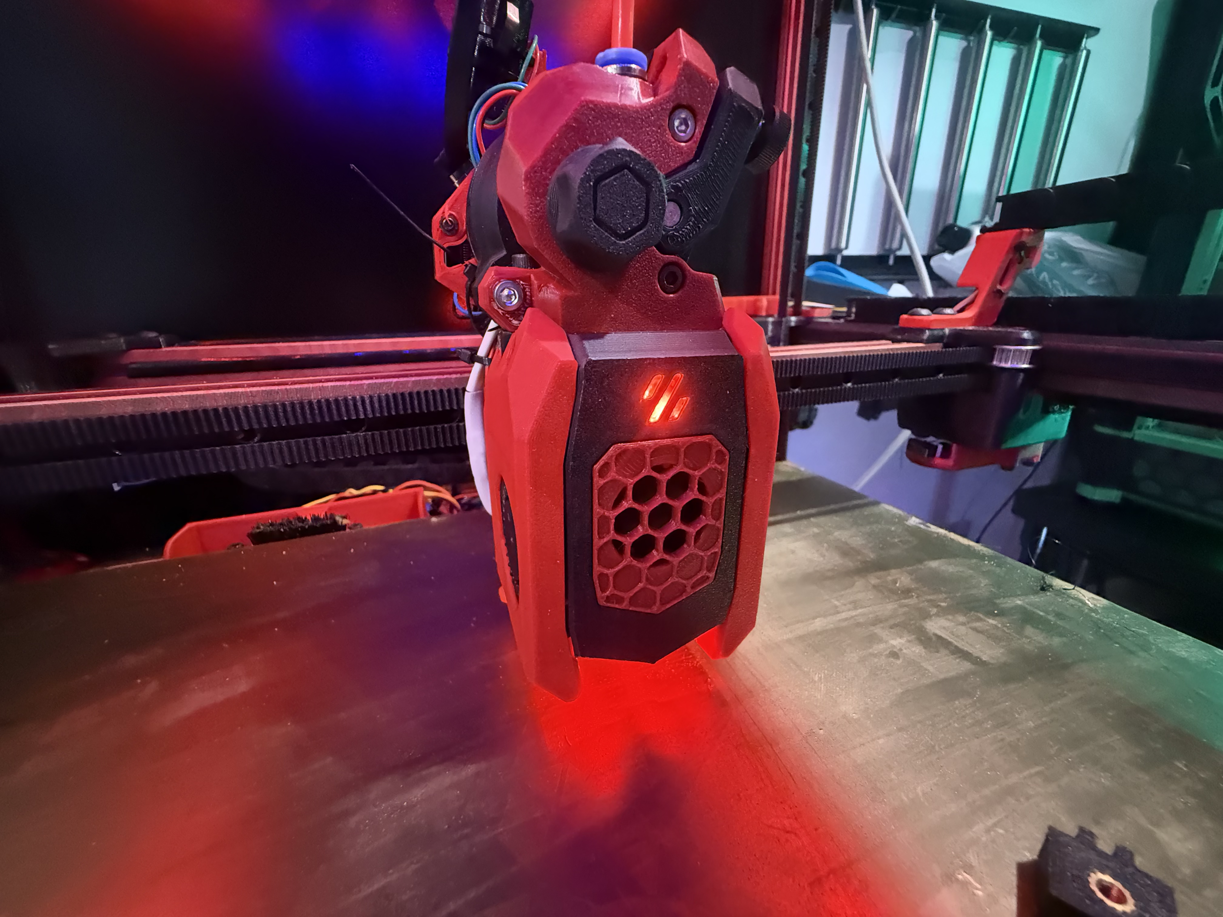 Close-up of a 3D printer toolhead over its build plate